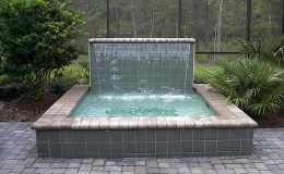 spa-with-raised-wall-and-sheer-descent-waterfall